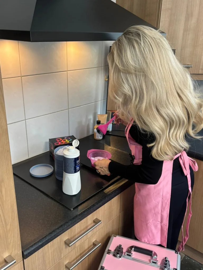 Elfi maakt de haarkleuring aan in de keuken van een klant
