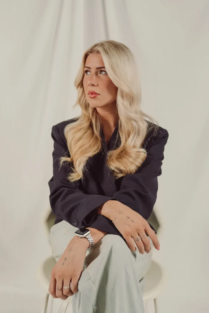 Elfi zittend in een donkere blazer