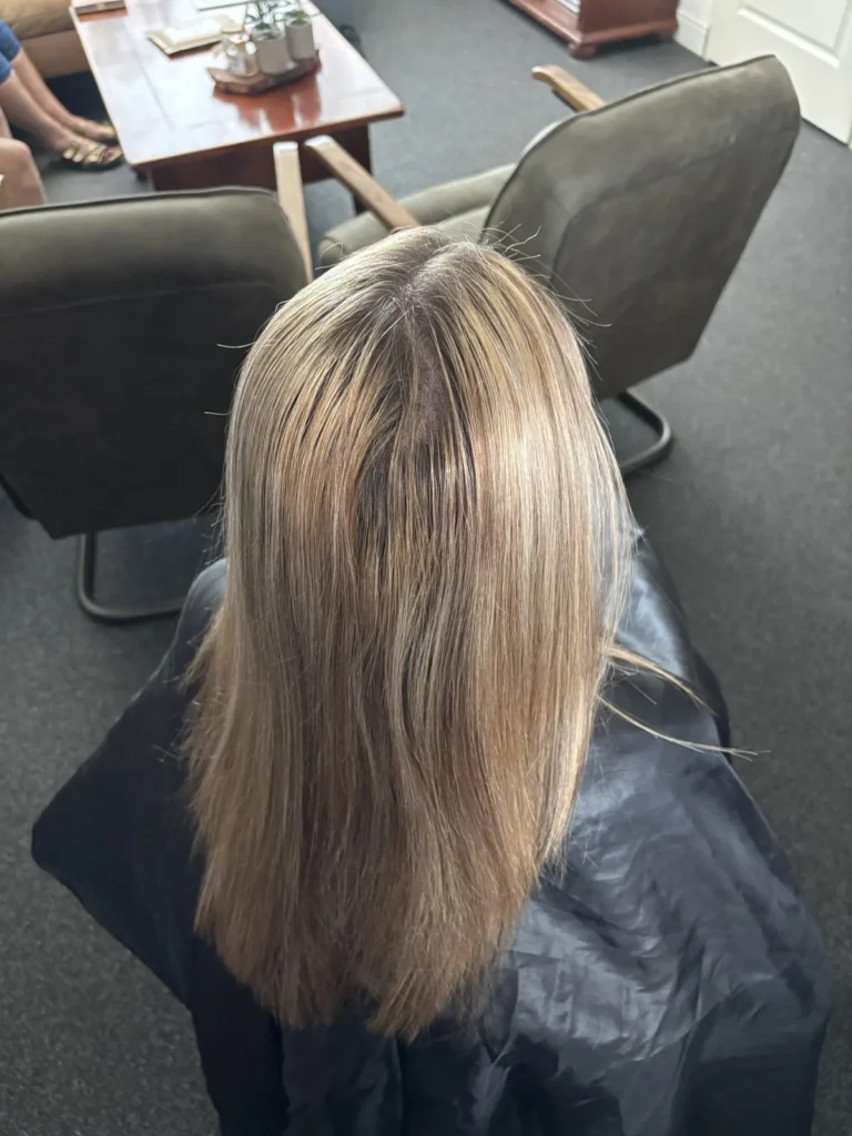 Schouderlang goudblond haar met een smalle donkere aanzet, voor de kleurbehandeling